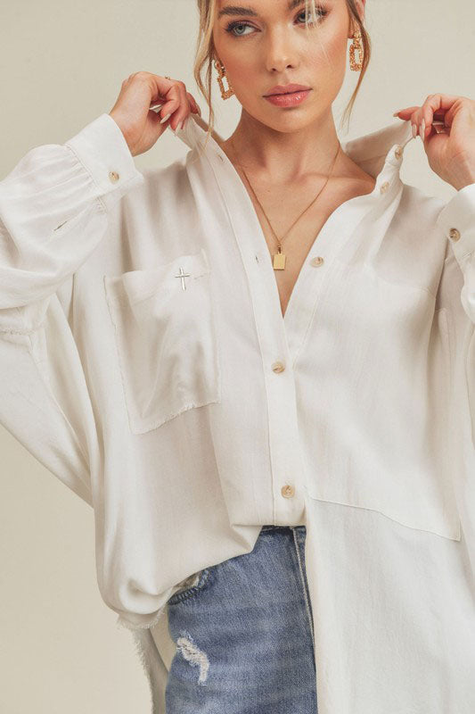 CHRISTIAN FASHION CLOTHING BRAND - ATALIE THE LORD IS EXALTED. The Phoebe Top is an essential button down. This forever classic style is slouchy, has an oversized fit and raw edge detailing that adds the perfect shape to any look. Our signature cross can be found on the right front pocket. 100% Cotton Imported